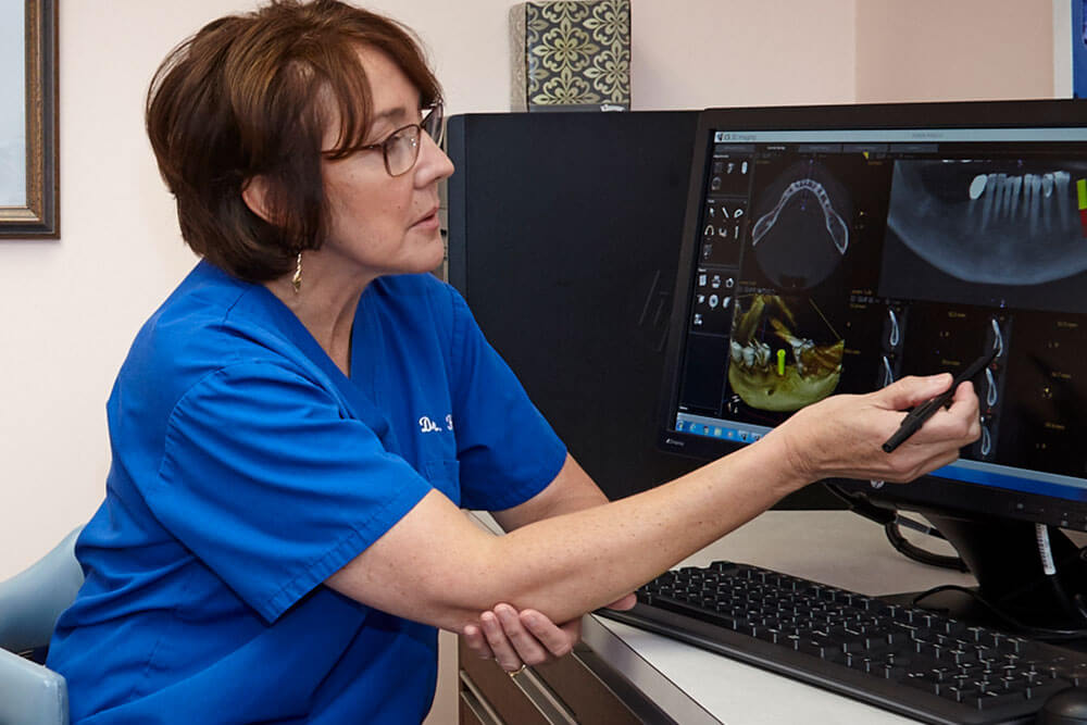 Dr. Anne Hartnett reviewing x-rays of patient on computer screen